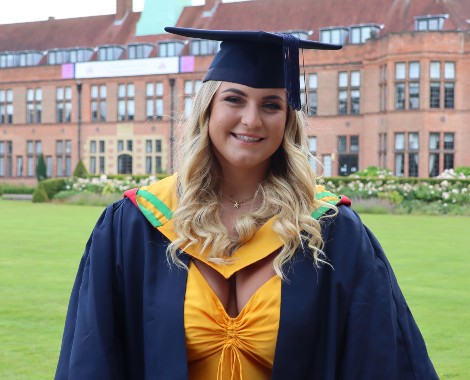 A female student wearing a graduation cap and gown.